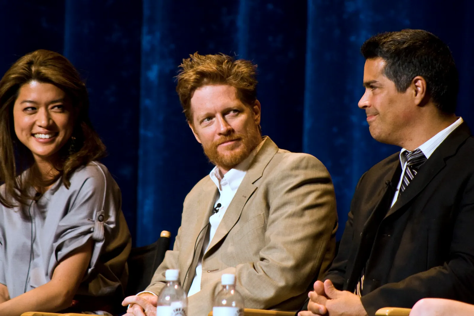 documentary photograph of actors Grace Park, Eric Stoltz and Esai Morales at the 2009 PaleyFest *Battlestar Galactica/Caprica* panel. Original page: https://commons.wikimedia.org/wiki/File:Eric_Stoltz-2009.jpg. Photographer: Oscalito. License: CC BY-SA 2.0. Attribution: Oscalito, CC BY-SA 2.0, via Wikimedia Commons; no edits.