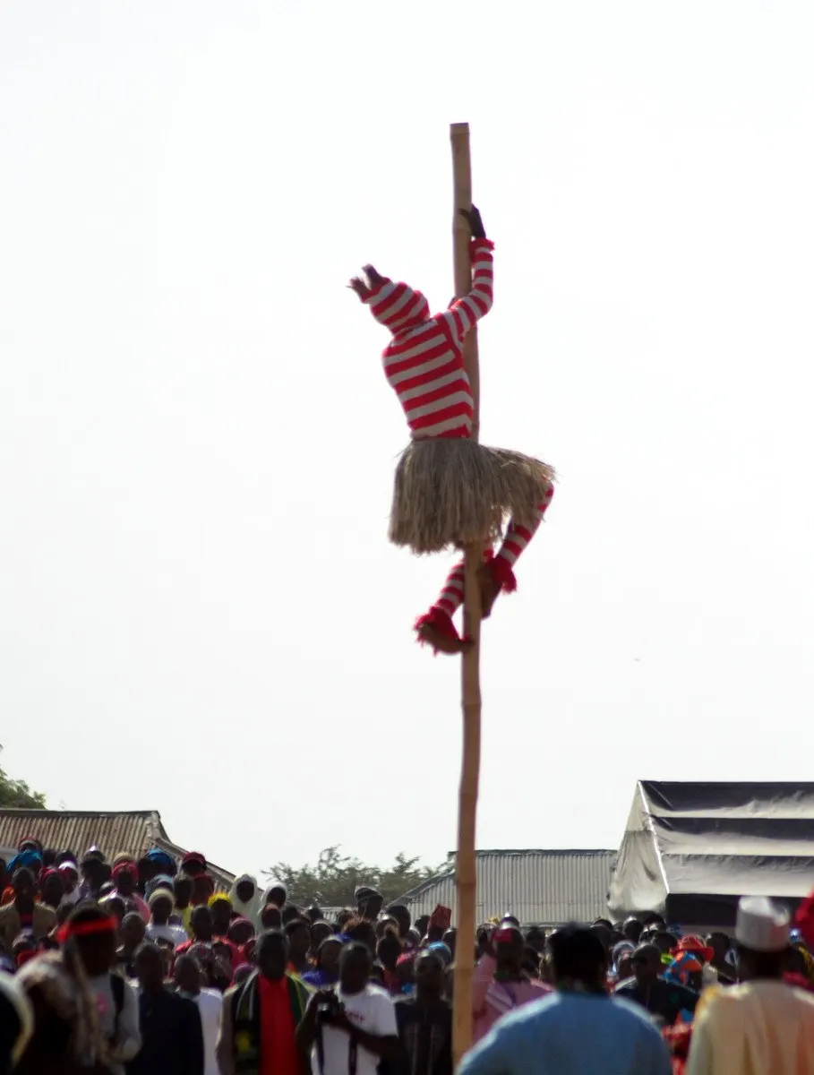 pole acrobat performing at an event; photographer Dotun55; CC BY-SA 4.0. Original: https://commons.wikimedia.org/wiki/File:Pole_Acrobat.jpg. Attribution: Dotun55, CC BY-SA 4.0, via Wikimedia Commons. Visually inspected 2026-10-18.