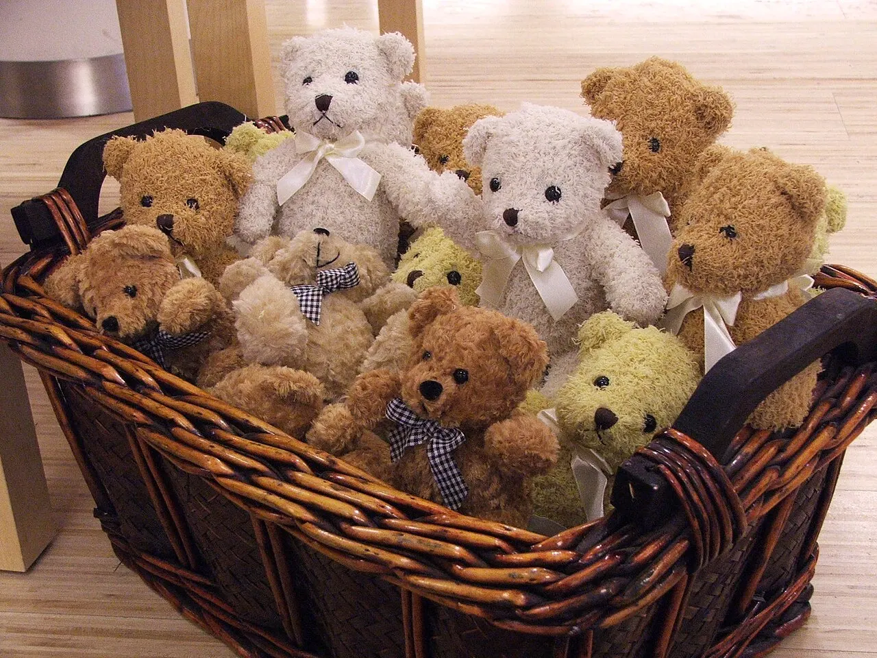 approximately 15 teddy bears in a basket; contextual photograph, not from Jackie Miley’s collection. Björn Láczay, Wikimedia Commons, https://commons.wikimedia.org/wiki/File:Teddy_bears_in_a_basket.jpg, CC BY-SA 2.0 (https://creativecommons.org/licenses/by-sa/2.0/). Attribution: Björn Láczay, “Teddy bears in a basket,” CC BY-SA 2.0, via Wikimedia Commons. Resized download (`?width=1200`); checked 2026-10-18.