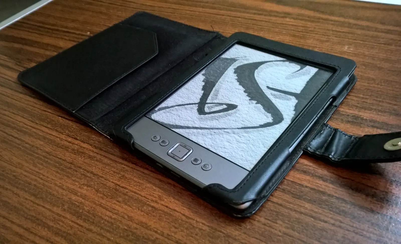 documentary photograph of an Amazon Kindle (4th generation) e-reader in a case; it is a real device, not a PADD prop. Photographer/creator: Hexafluoride (own work). [Original file page](https://commons.wikimedia.org/wiki/File:Kindle_4th_Generation.jpg), [CC BY-SA 4.0](https://creativecommons.org/licenses/by-sa/4.0/). Attribution: “Hexafluoride / Wikimedia Commons / CC BY-SA 4.0”; no edits. Downloaded original 2841 × 1728 JPEG and visually checked.