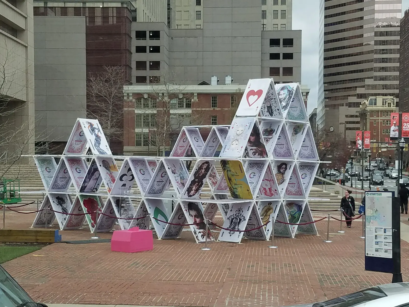 documentary photograph of a life-size house of cards on a Baltimore sidewalk, 1 April 2017; not Berg’s structure. Original page: https://commons.wikimedia.org/wiki/File:Life-size_House_of_Cards.jpg. Creator Crystal Vance (Wikimedia username Literallyme95). CC BY-SA 4.0; attribution: Crystal Vance, “Life-size House of Cards,” CC BY-SA 4.0, via Wikimedia Commons. License: https://creativecommons.org/licenses/by-sa/4.0/.
