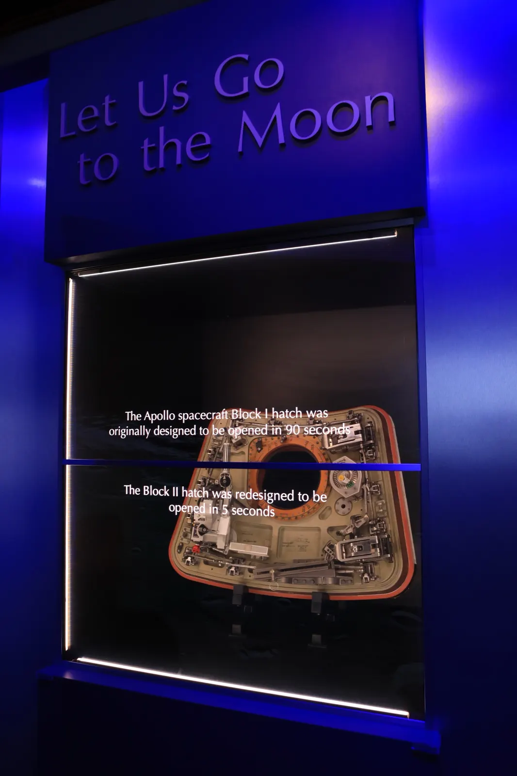 Redesigned Block II hatch displayed at the Apollo/Saturn V Center memorial exhibit, photographed 24 January 2017. NASA/Kim Shiflett; public domain in the United States. This is an exhibit photograph of a redesigned hatch, not the original Apollo 1 hatch. Wikimedia: https://commons.wikimedia.org/wiki/File:Apollo_1_Tribute_Block_II_hatch.JPG. Resized from 4480 × 6720 to 1493 × 2240 pixels for delivery.