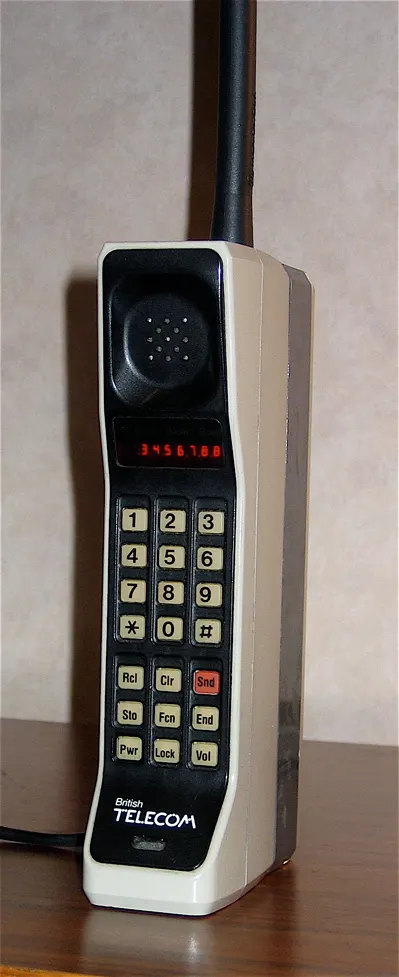 documentary photograph of a Motorola DynaTAC 8000X mobile phone from 1984. Photographer: Redrum0486, 2008. Original page: https://commons.wikimedia.org/wiki/File:DynaTAC8000X.jpg. CC BY-SA 3.0 (or GFDL as offered on the page); attribution: “Redrum0486 / Wikimedia Commons / CC BY-SA 3.0”; no edits.