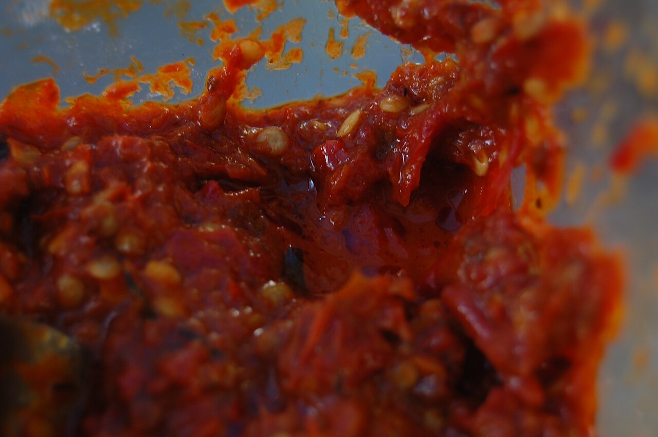 A sambal is a chili based sauce which is normally used as a condiment. Sambals are popular in Indonesia, Malaysia, Singapore, the southern Philippines and Sri Lanka, as well as in the Netherlands and in Suriname through Indonesian influence. It is typically made from a variety of peppers, although chili peppers are the most common. It is sometimes a substitute for fresh chilis. It can be extremely spicy for the uninitiated. Some ready-made sambals are available at exotic food markets or gourmet departments in supermarkets in many countries.. Original file: [Sambalcabe.JPG](https://commons.wikimedia.org/wiki/File%3ASambalcabe.JPG). Creator: Hariadhi. License: CC BY-SA 3.0 (https://creativecommons.org/licenses/by-sa/3.0). Attribution: Hariadhi. Downloaded from the verified Commons file page; unaltered image. Checked 2026-10-25.