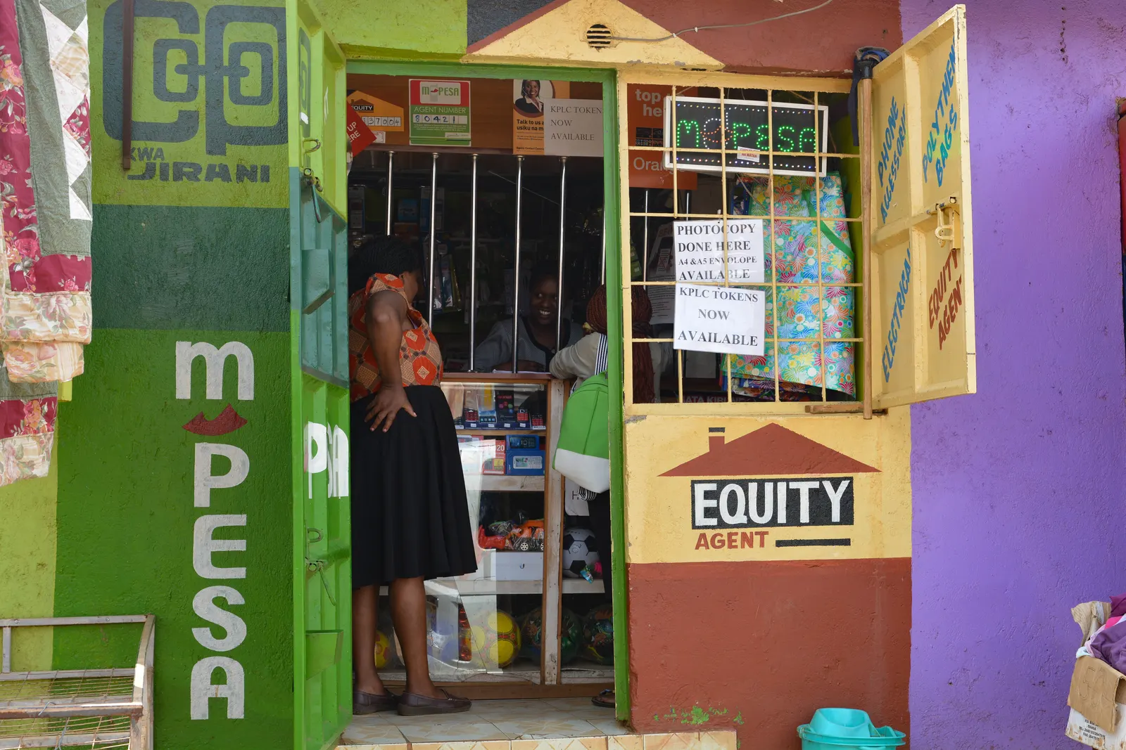 Fiona Graham, M-PESA mobile money and Equity agent outlet in Nairobi, photographed 13 October 2016. Wikimedia Commons, CC BY-SA 2.0. Original image, no edits. https://commons.wikimedia.org/wiki/File:M-PESA_mobile_money_and_Equity_agent,_Nairobi,_Kenya.jpg