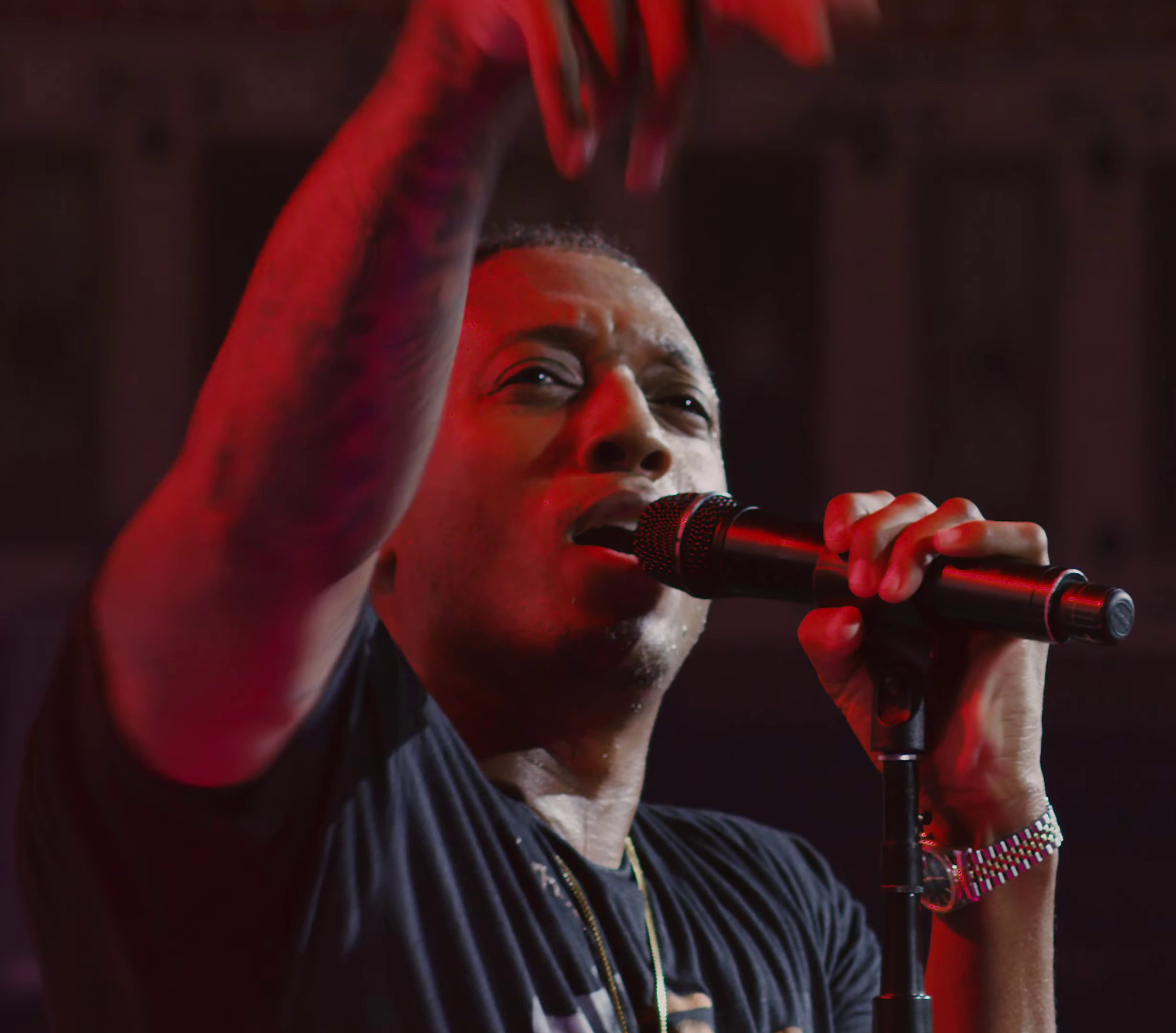 Rapper Lecrae performing with a microphone; Raymond McCrea Jones, CC BY-SA 3.0. Wikimedia Commons page: https://commons.wikimedia.org/wiki/File:Lecrae_holding_microphone_during_performance.jpg. Attribution to Raymond McCrea Jones; no edits. Lecrae is not NoClue; this is a generic performance image.