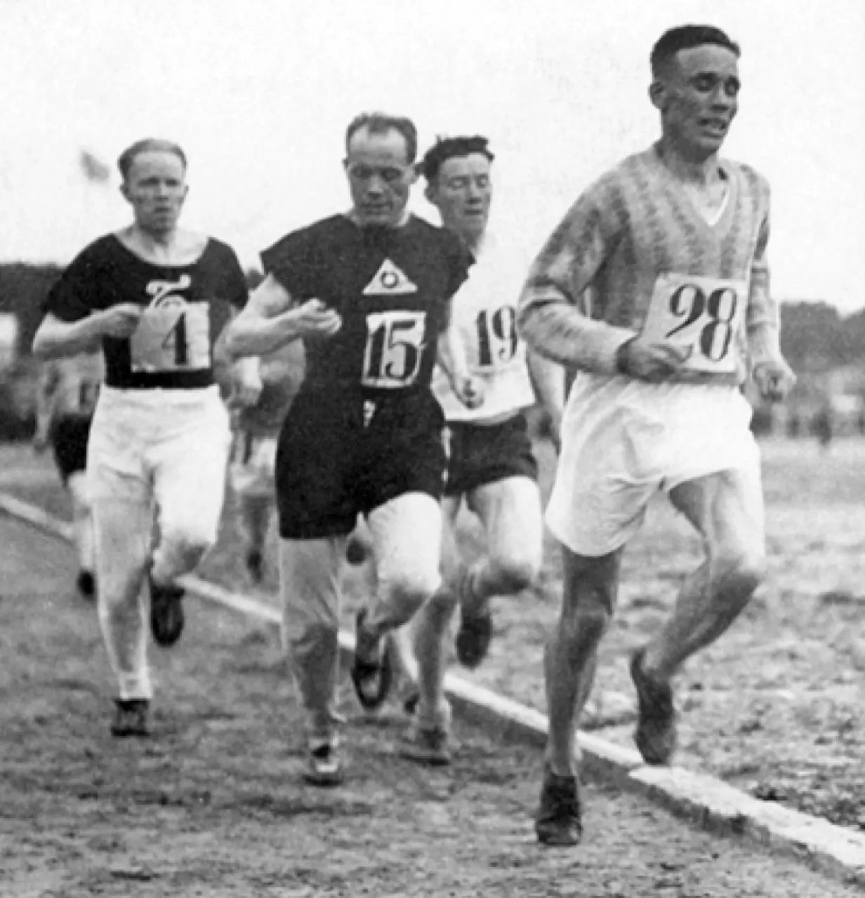 Paavo Nurmi running behind leader Ville Ritola in a 5,000-metre race in Porvoo, May 1928; contextual historic photograph of timed sport, not a Guinness record attempt. Photographer unknown; credited by Wikimedia Commons to the Sports Museum of Finland, https://commons.wikimedia.org/wiki/File:Paavo_Nurmi_checks_his_stopwatch_in_1928.jpg; public domain. Resized to 1280 px longest dimension; checked 2026-10-18.