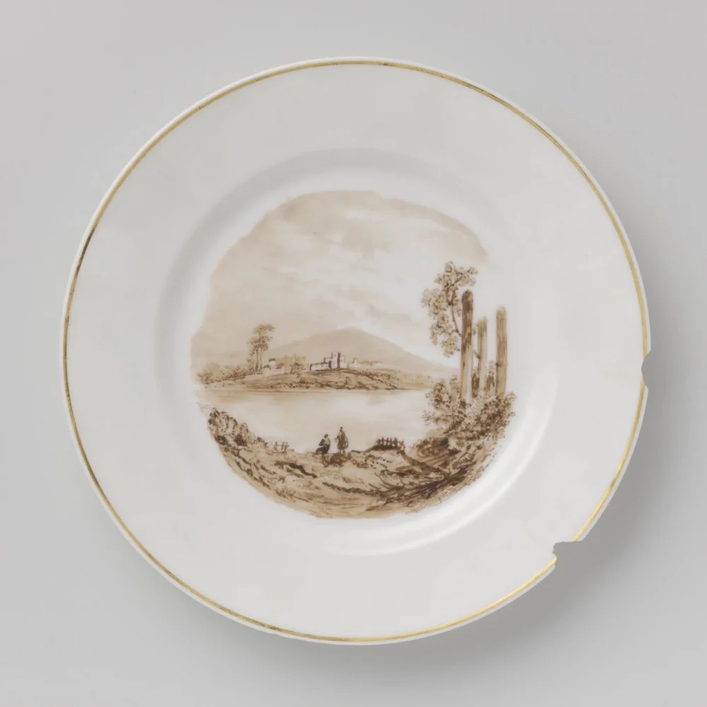 Period example of hand-painted porcelain, not attributed to Renoir: plate with landscape, porcelain painter A.T. Vaillant, circa 1850–1860. Rijksmuseum object BK-1969-154-17: https://www.rijksmuseum.nl/en/collection/object/Plate-with-a-landscape--49347e8debce6a668804fad1681e8dbd . Rijksmuseum identifies it as porcelain painted in sepia and gold and lists copyright status as Public domain. Retrieved via the Rijksmuseum IIIF image service; converted from WebP to JPEG without cropping. Checked 2026-10-28.