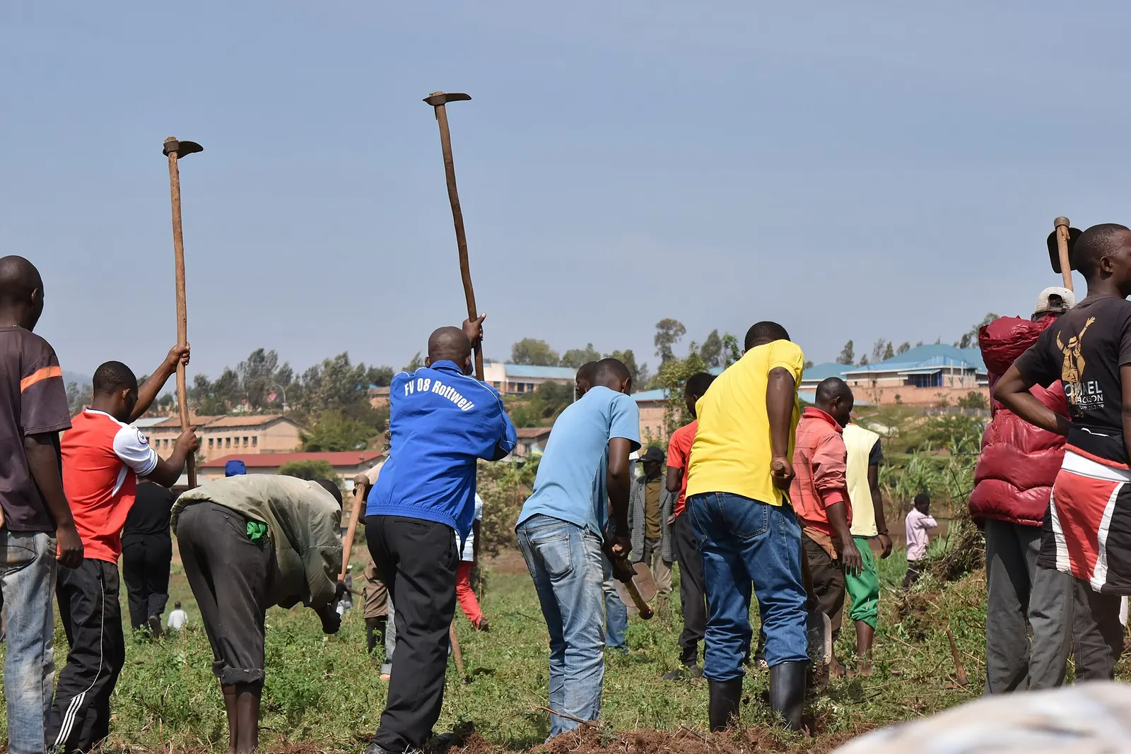 photo captioned as Umuganda community work, depicting residents working together; 30 July 2011, Kicukiro District. Creator Masako Kato, photographed 30 September 2017; CC BY-SA 4.0. Original file page: https://commons.wikimedia.org/wiki/File:Umuganda.jpg. Attribution: Masako Kato, “Umuganda,” CC BY-SA 4.0. No edits.