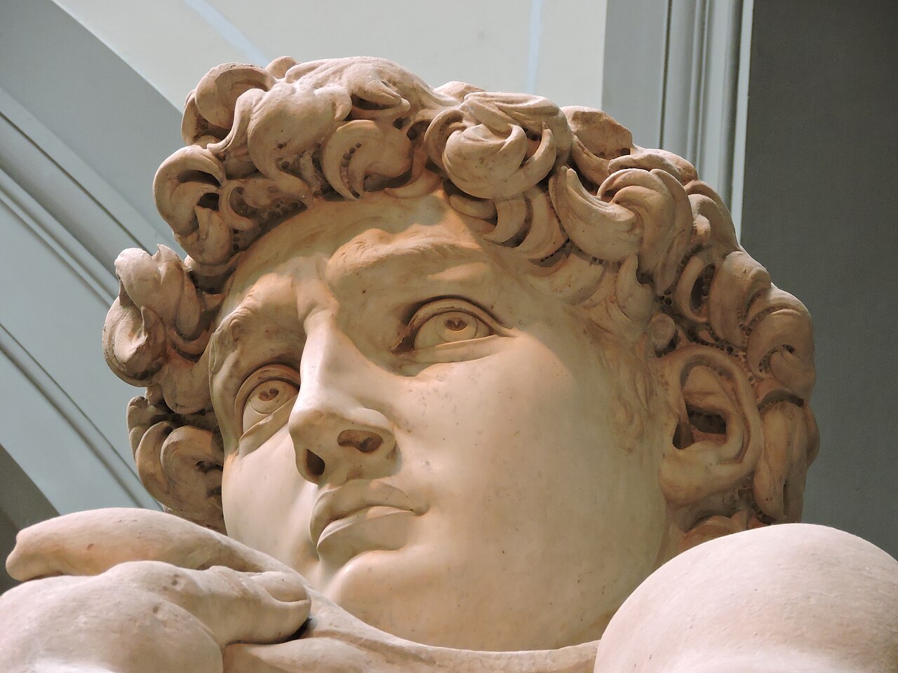 close view of the statue’s face and upper body in the same gallery; photograph by Dimitris Kamaras, 2016; CC BY 2.0. Credit: Dimitris Kamaras, Wikimedia Commons; link to https://creativecommons.org/licenses/by/2.0; no edits. Original file page: https://commons.wikimedia.org/wiki/File:Michelangelo%27s_David%2C_Galleria_dell%27Accademia%2C_Florence_%2826404331700%29.jpg. Downloaded the 1,280 × 960 px Commons version on 2026-10-28.