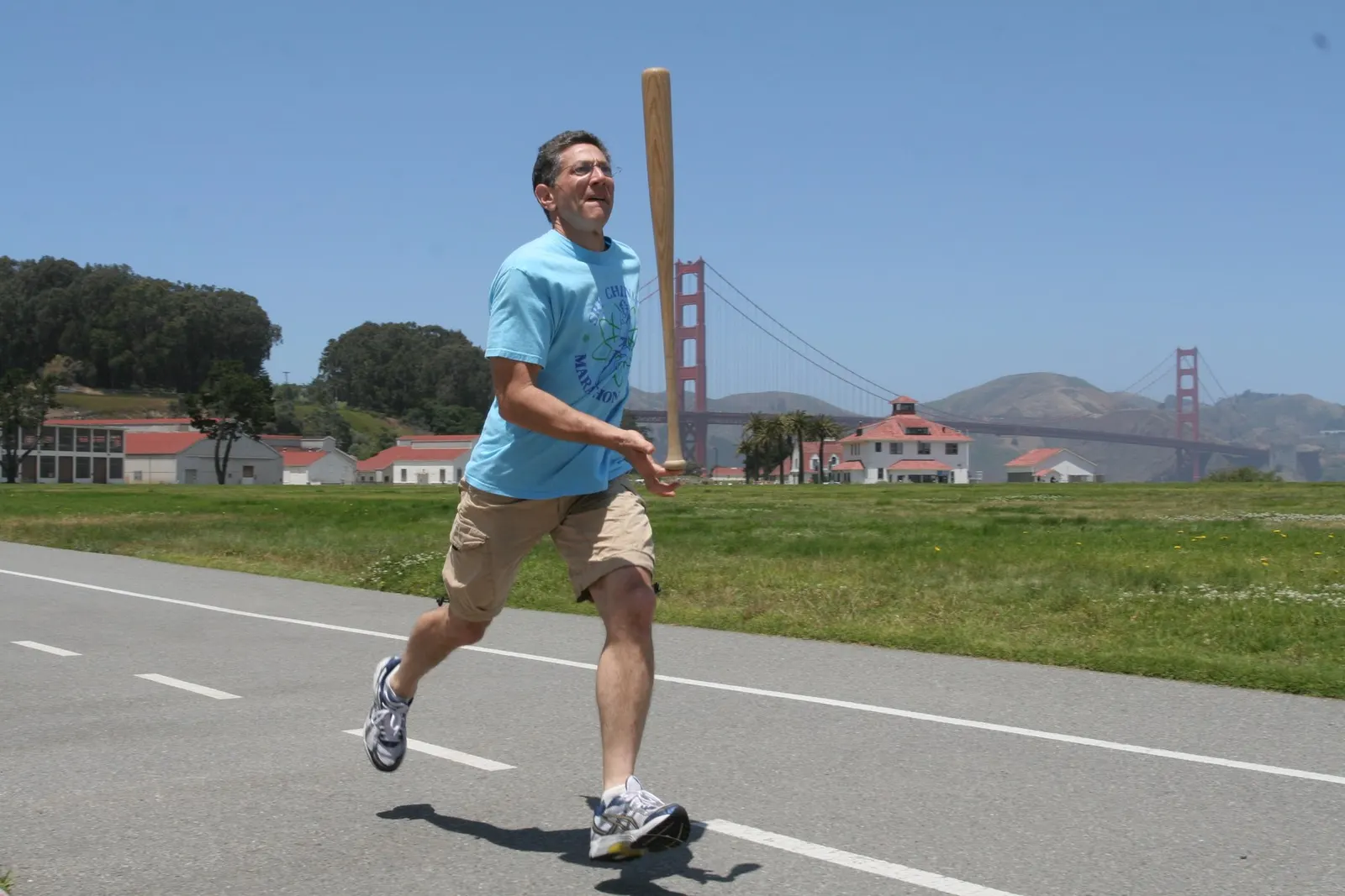 Ashrita Furman running while balancing a baseball bat on his hand, performing a different record feat in 2008; public domain, photographer/uploader Northstar77777. Source: https://commons.wikimedia.org/wiki/File:AshritaSettingBat-BalancingRecord.JPG. This does not show the Swiss-ball attempt.