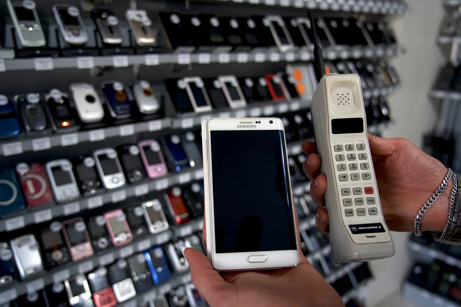 Umut Çolak, DynaTAC and Samsung Galaxy Note Edge, photograph dated 22 November 2021. Voice of America image via Wikimedia Commons; public domain in the United States as U.S. government-created material. Wikimedia 1,920-pixel rendition; no additional edits. https://commons.wikimedia.org/wiki/File:Motorola_DynaTAC_and_Samsung_Galaxy_Note_Edge.jpg