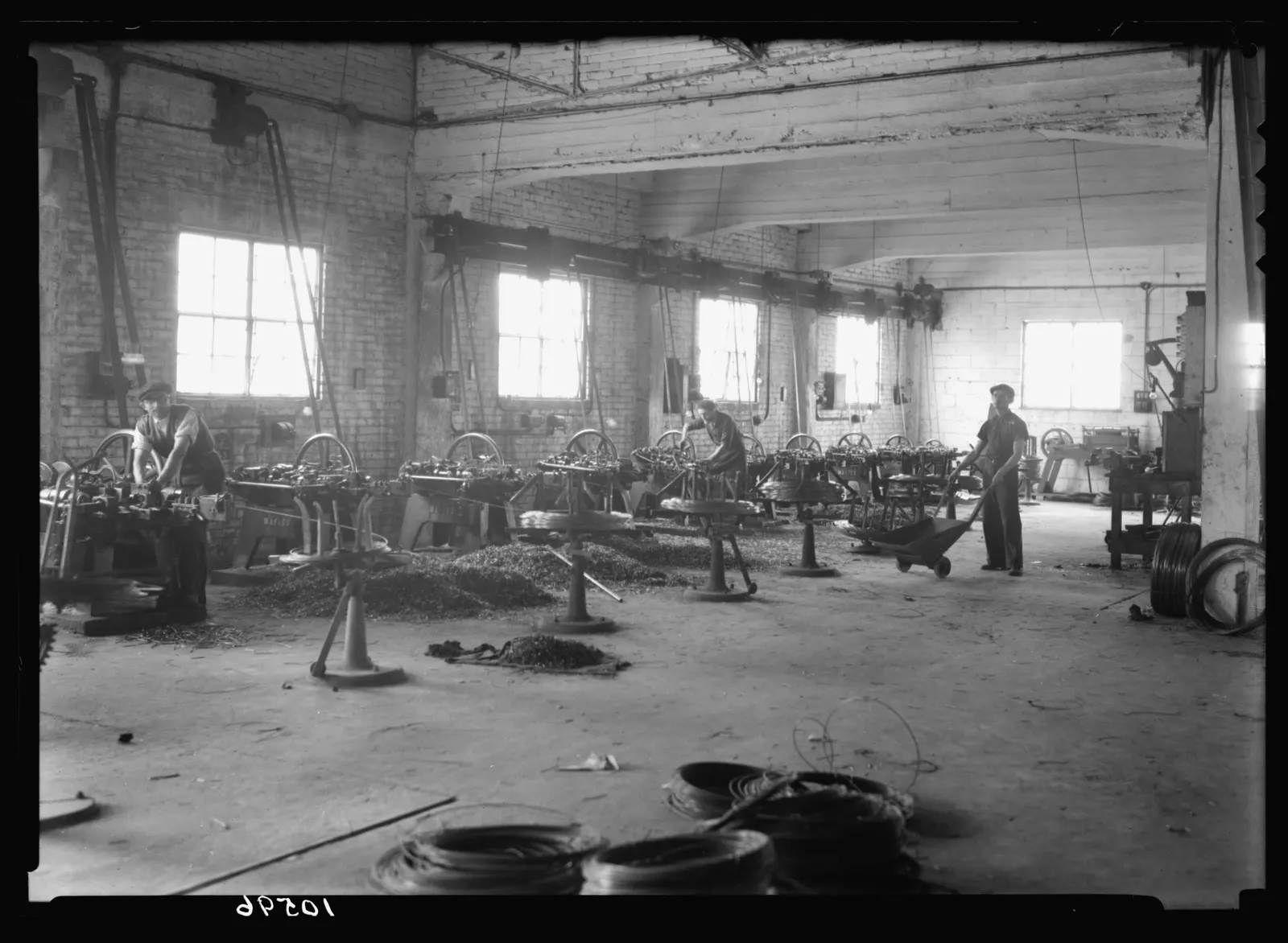 documentary photograph of workers at a wire-drawing and nail factory, Petah Tikvah, 1939; G. Eric and Edith Matson Photograph Collection, Library of Congress; the LOC reports no known restrictions, Commons identifies the work as public domain in the U.S. Original page: https://commons.wikimedia.org/wiki/File:Jewish_factories_in_Palestine_on_Plain_of_Sharon_%26_along_the_coast_to_Haifa._Petah-Tikvah._Wire_drawing_%26_nail_factory._%27Barzelit,%27_Ltd._Some_of_the_wire_drawn_is_transformed_into_nails_LOC_matpc.22480.jpg. Courtesy attribution: Matson Collection / Library of Congress. It documents later wire-nail production outside the United States and is not presented as a U.S. factory in 1913. No edits.