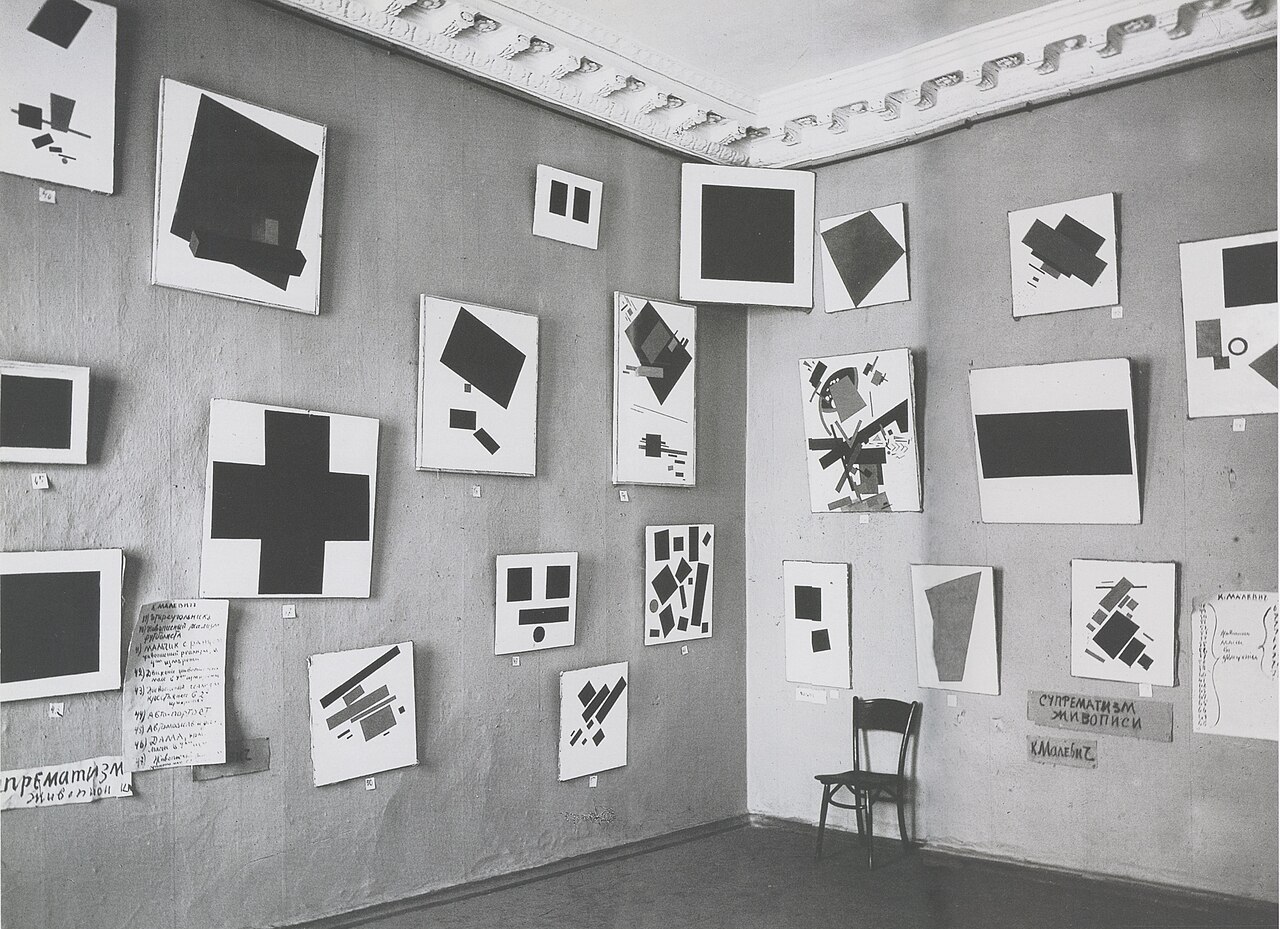 Архівне фото виставки «0,10» 1915 року / Archival photo of the 0.10 exhibition in 1915, showing Black Square high across the corner.