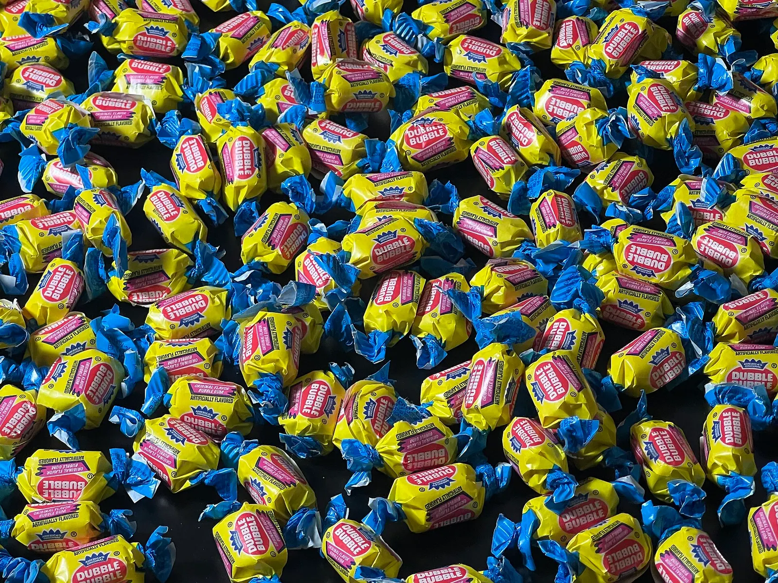 contextual documentary photograph of an assortment of Dubble Bubble gum, not the gum used by Fell. Original page: https://commons.wikimedia.org/wiki/File:Dubble_Bubble_Bubble_Gum.jpg. Creator TaurusEmerald. CC BY-SA 4.0 (https://creativecommons.org/licenses/by-sa/4.0/). Attribution: TaurusEmerald, “Dubble Bubble Bubble Gum,” CC BY-SA 4.0, via Wikimedia Commons.
