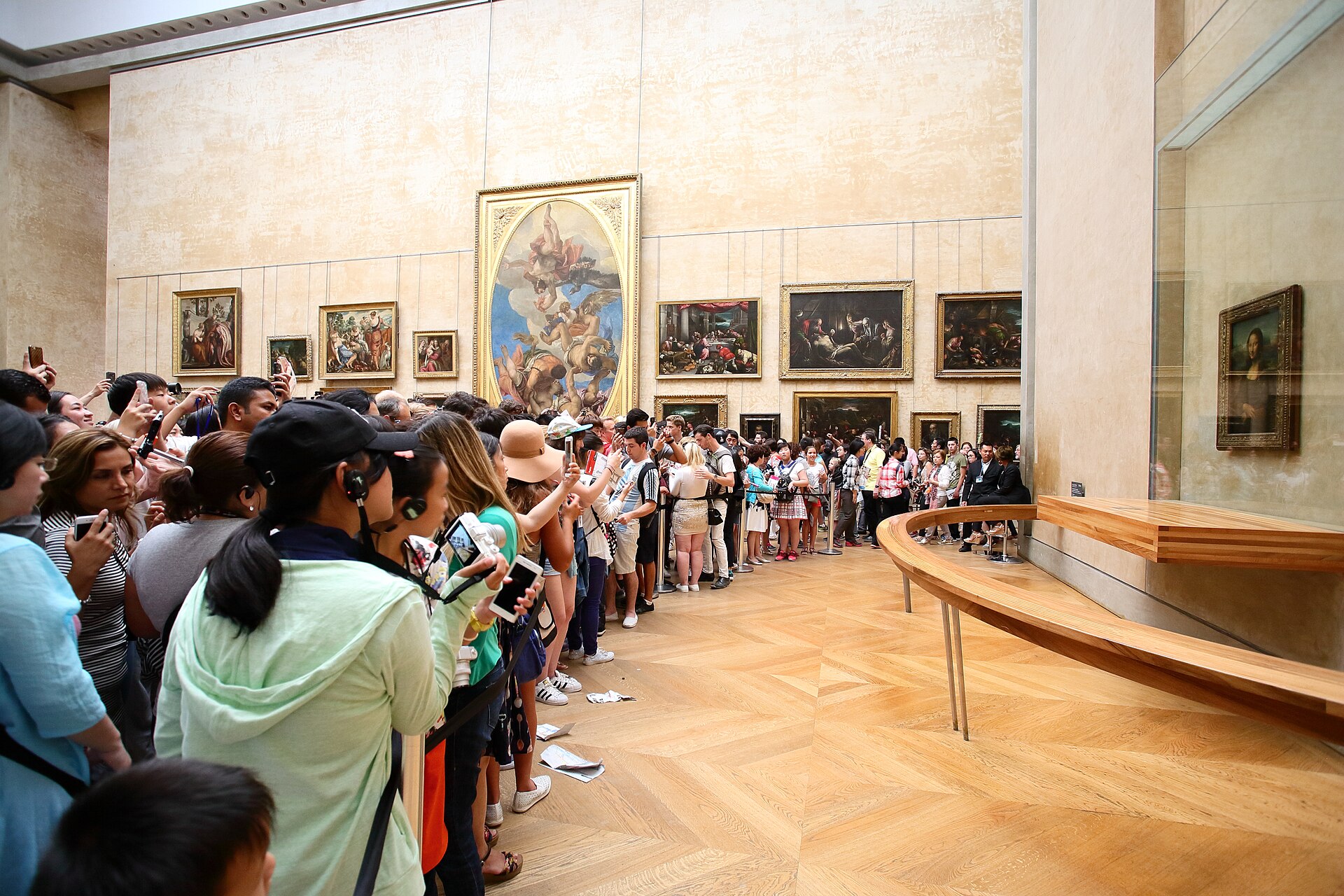 visitors gathered by the Mona Lisa and other works in the Louvre’s Salle des États; photograph taken 1 August 2016.