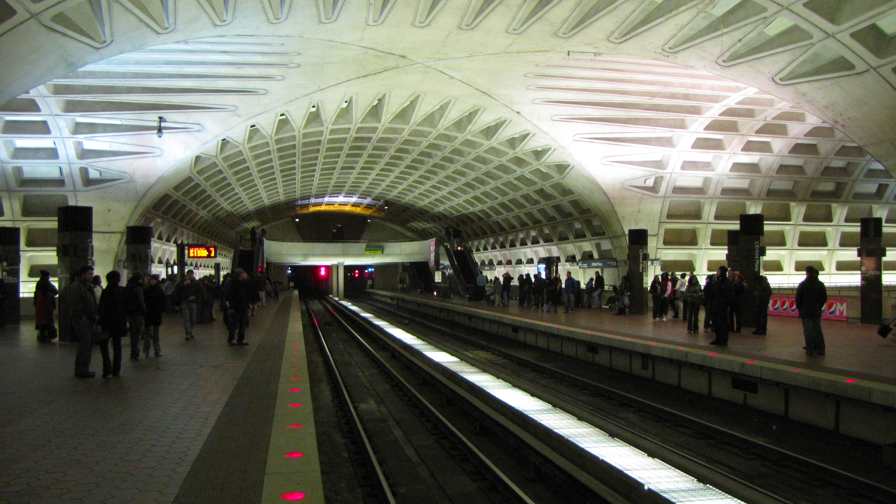 Upper level of L’Enfant Plaza station, photographed in 2009 (not the exact 2007 playing spot). Photographer Ben Schumin; https://commons.wikimedia.org/wiki/File:L%27Enfant_Plaza_upper_level,_facing_outbound.jpg; CC BY-SA 3.0. Attribution: “L’Enfant Plaza upper level, facing outbound” by Ben Schumin, CC BY-SA 3.0, via Wikimedia Commons. No edits.