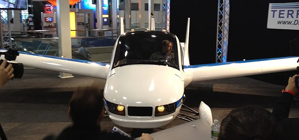 front view of the Transition prototype with wings extended at the New York International Auto Show, 5 April 2012. Photographer: Steve Cypher; published by LotPro Cars; CC BY-SA 2.0. Credit “Steve Cypher / LotPro Cars,” no changes. Original page: https://commons.wikimedia.org/wiki/File:Terrafugia_--_2012_NYIAS_--_head-on,_wings_unfolded.jpg.