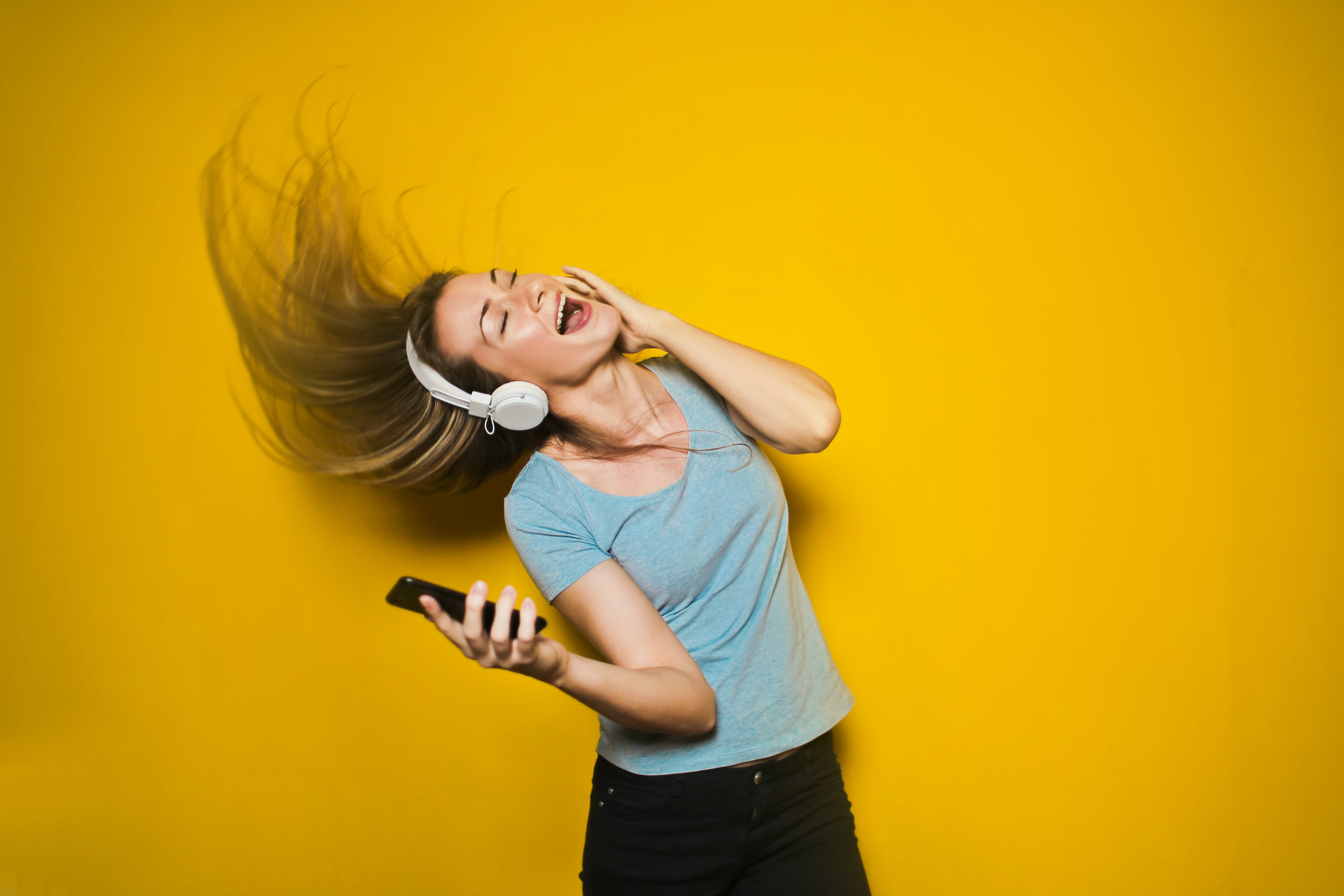 Photograph of a woman listening to music; Bruce Mars, originally published by Pexels; CC0 1.0 Public Domain Dedication as reviewed on Wikimedia Commons. Original asset page: https://commons.wikimedia.org/wiki/File:Girl_in_headphones.jpg. No attribution required; credit retained here. No material edit.